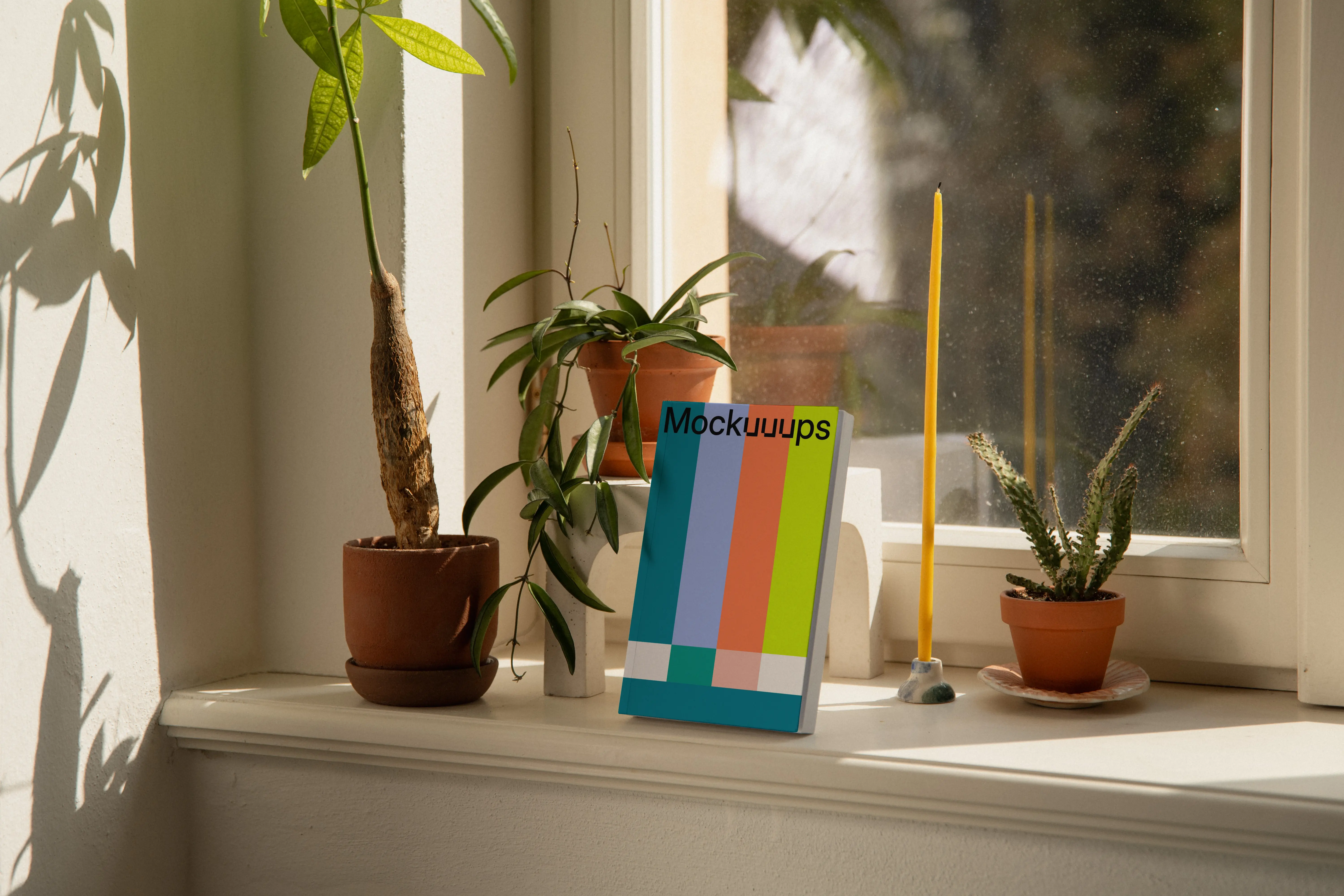 Softcover book mockup on a windowsill with plants