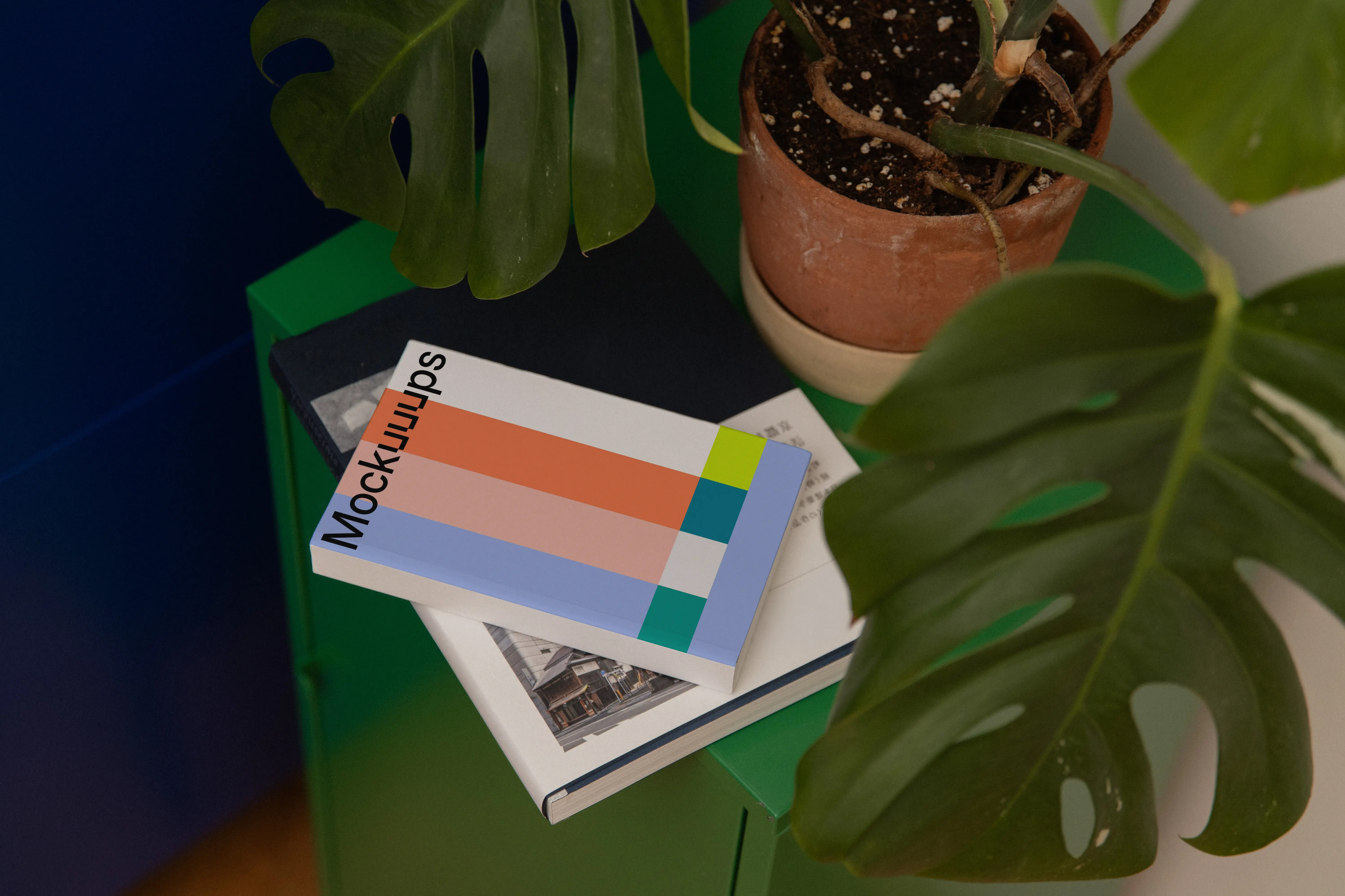 Softcover mockup on a green cabinet with plant