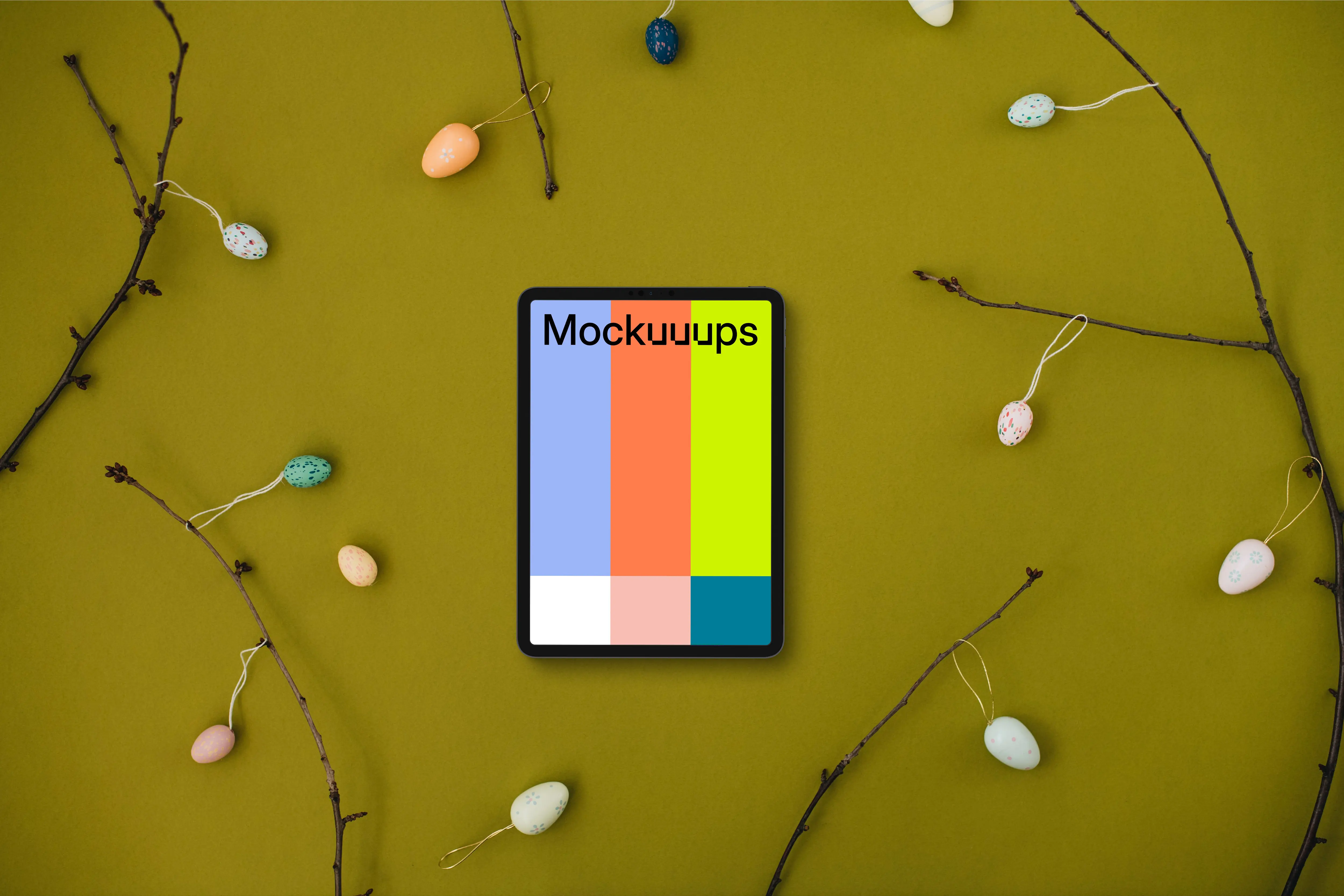 Tablet mockup among Easter eggs on branches