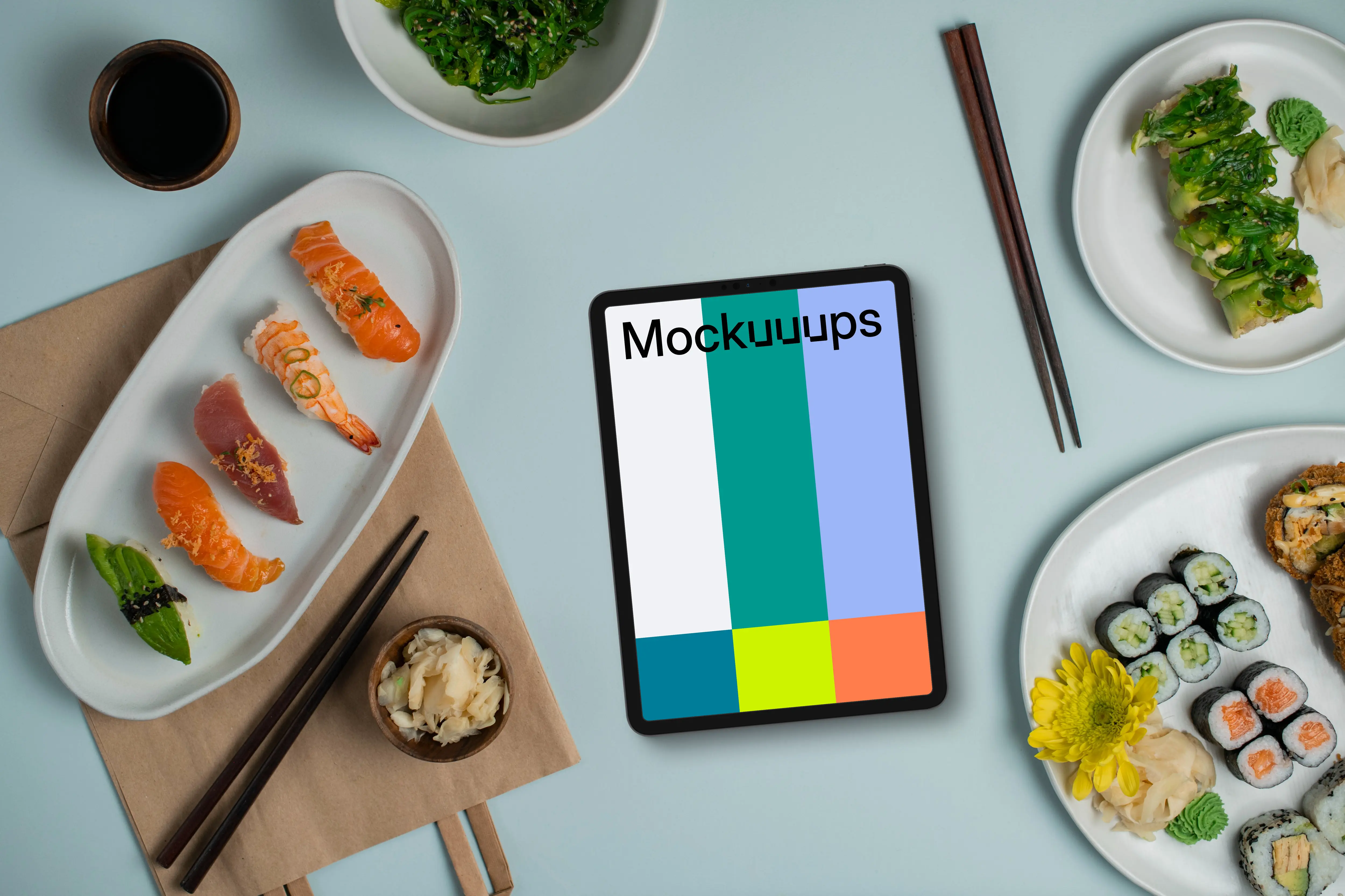 Tablet mockup between plates of sushi
