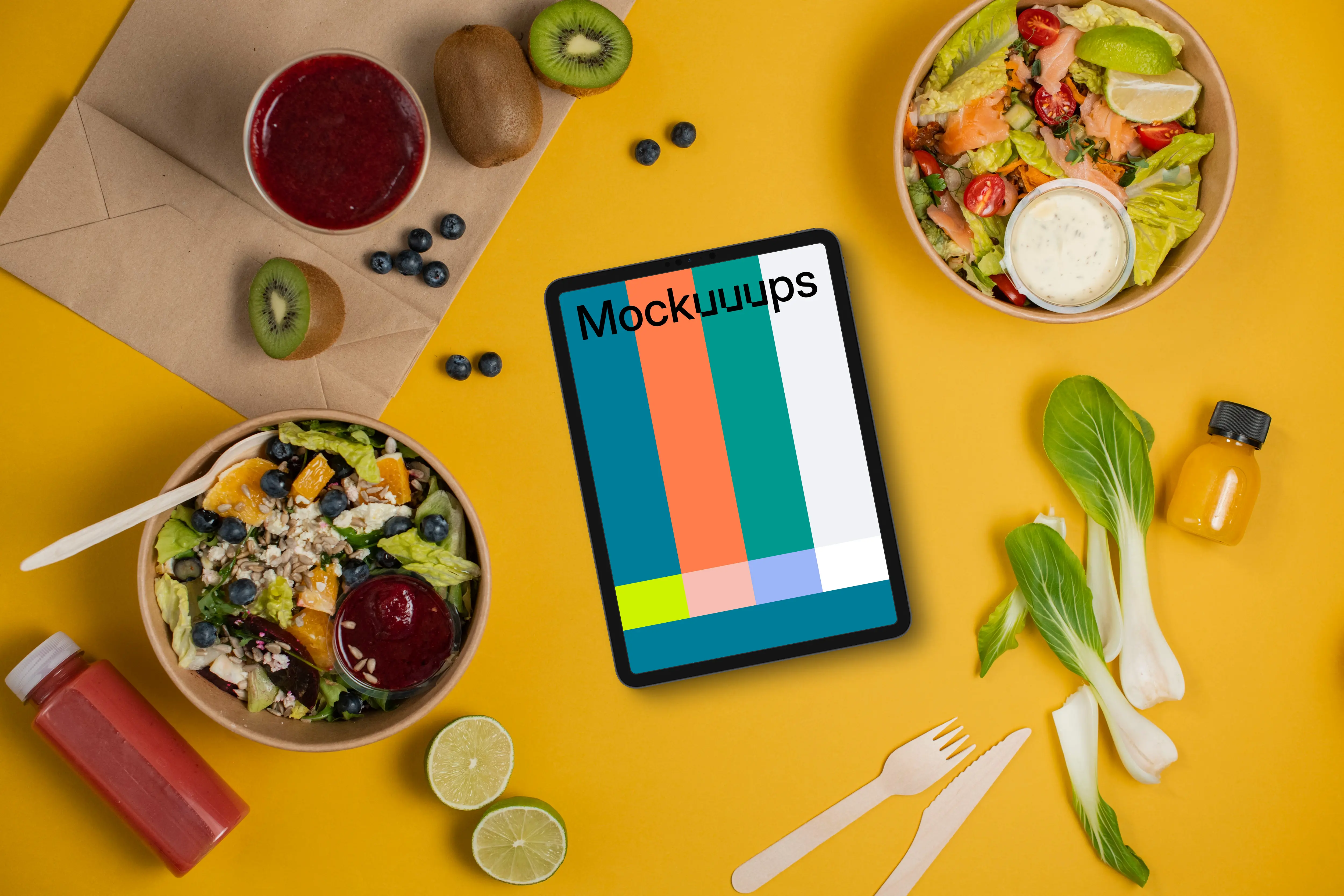 Tablet mockup surrounded by veggie salads and fruits