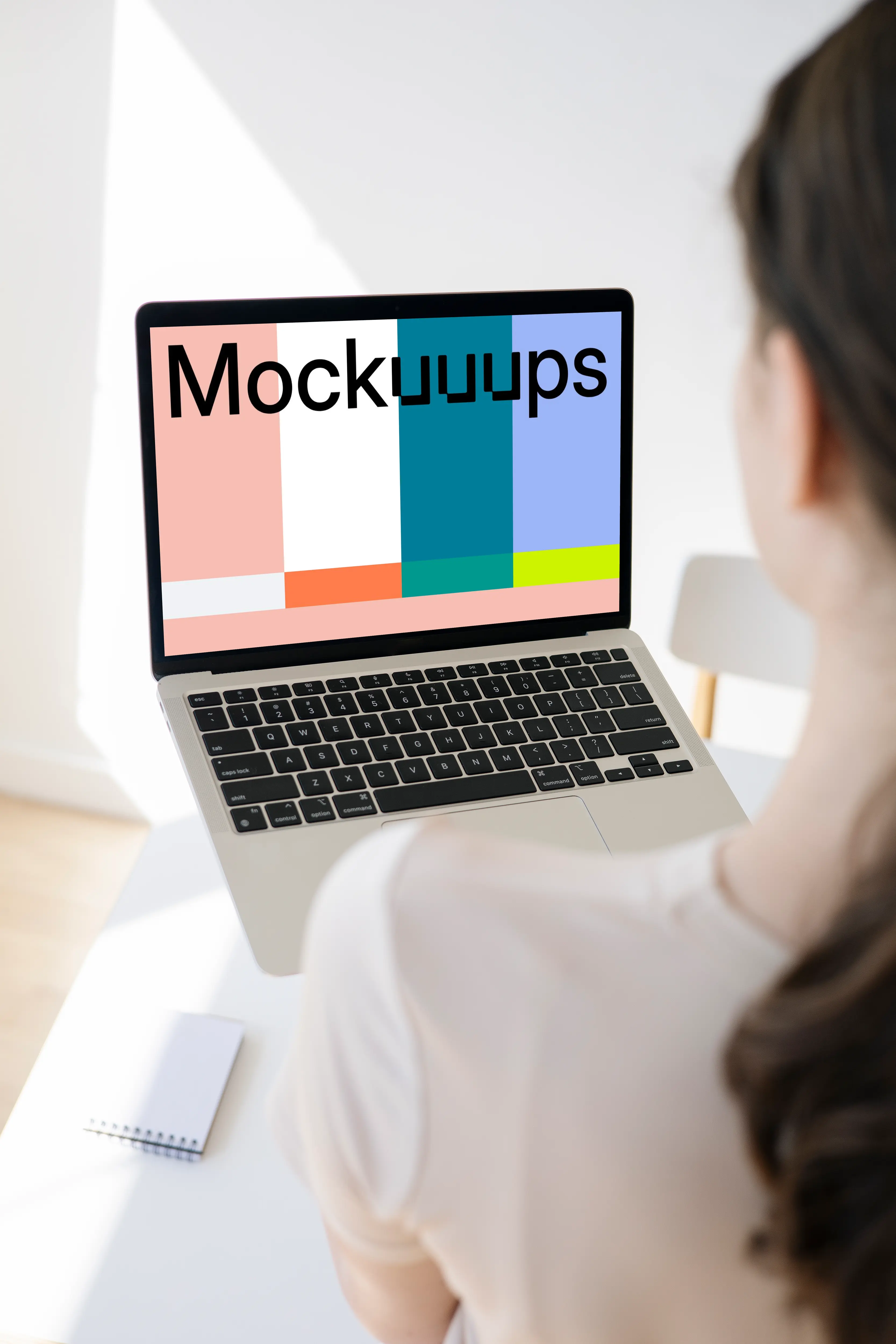 Woman holding a MacBook Pro mockup in a bright room