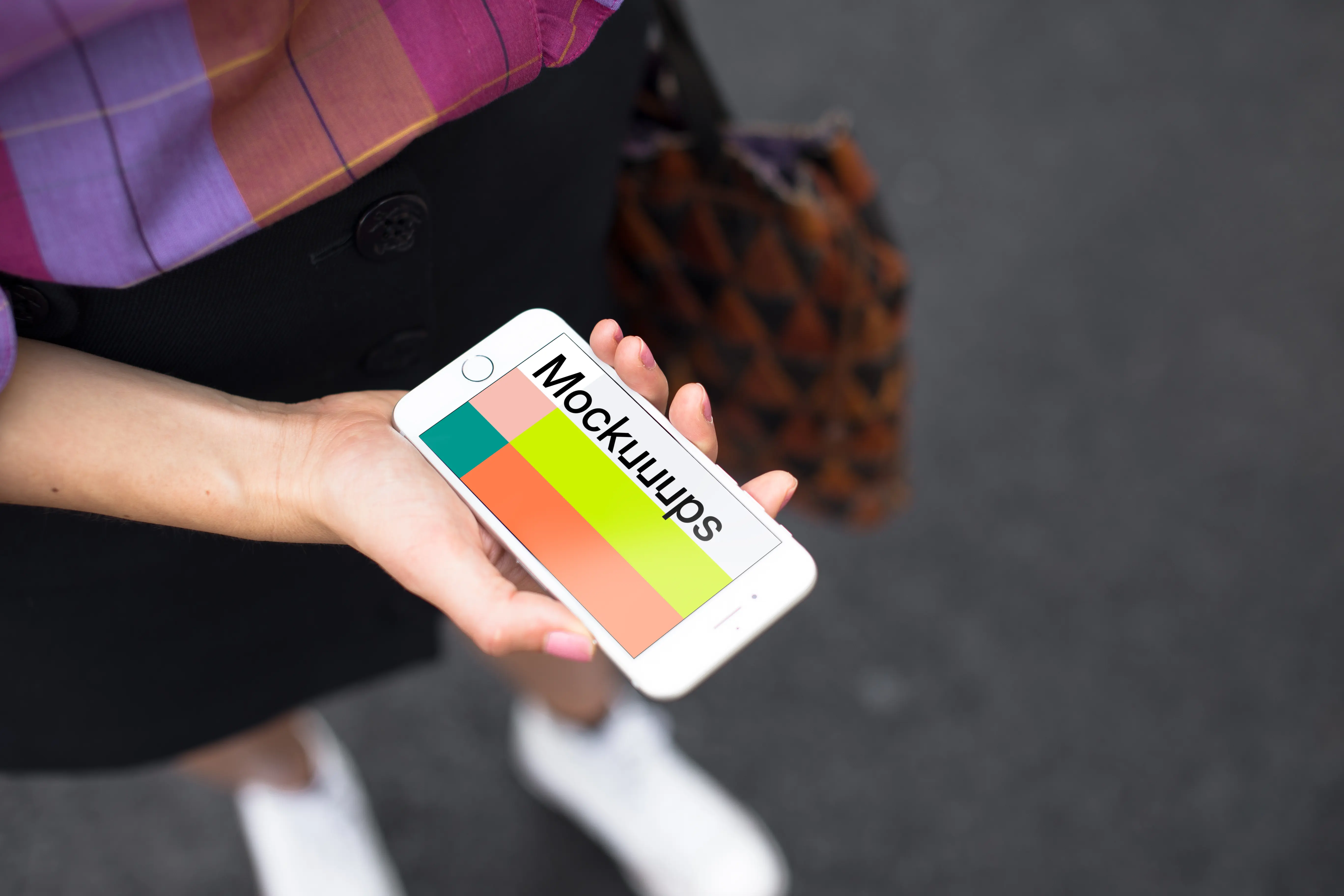 Woman holding iPhone 7 mockup on the street