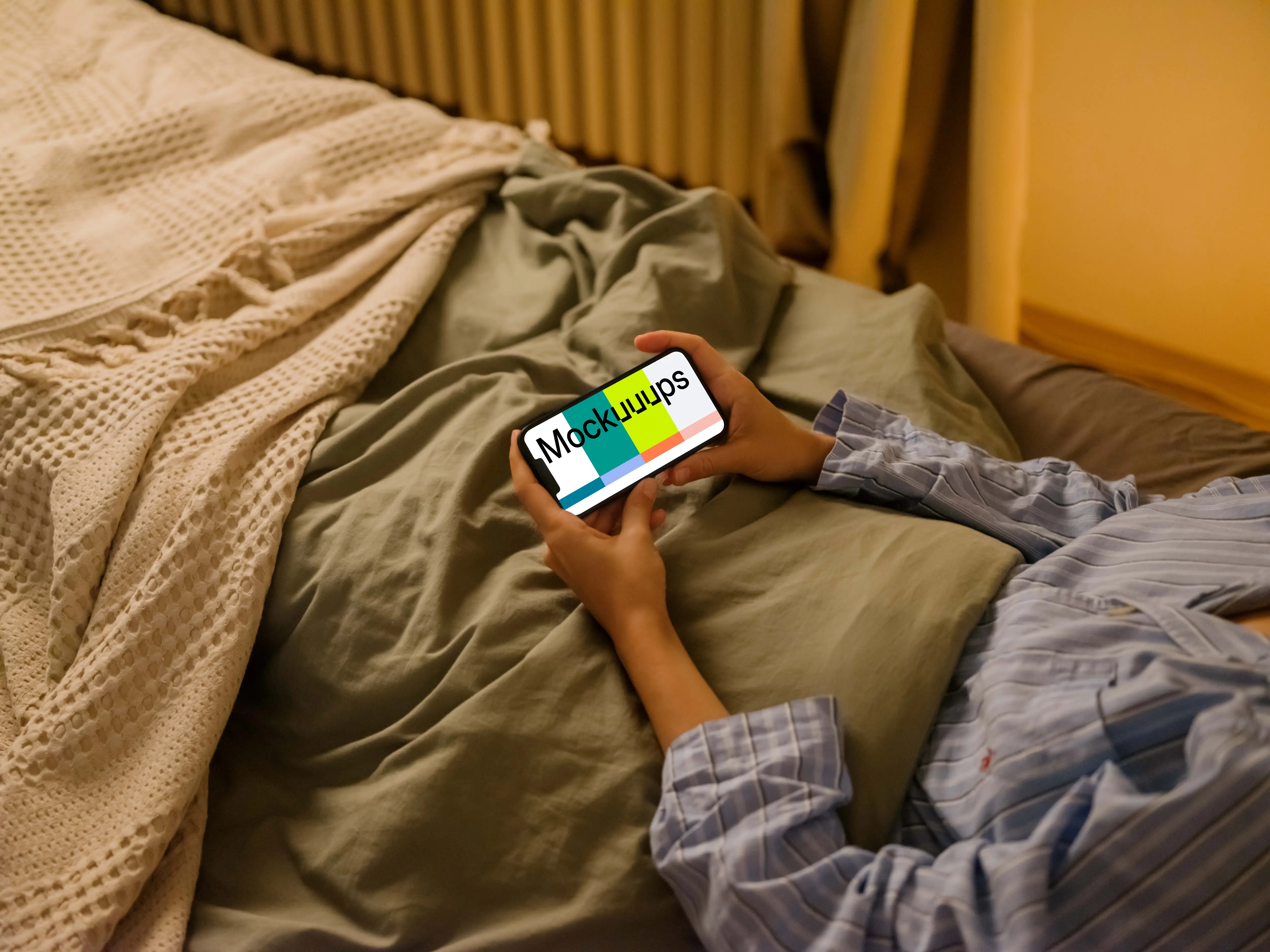 Woman in bed holding an iPhone mockup
