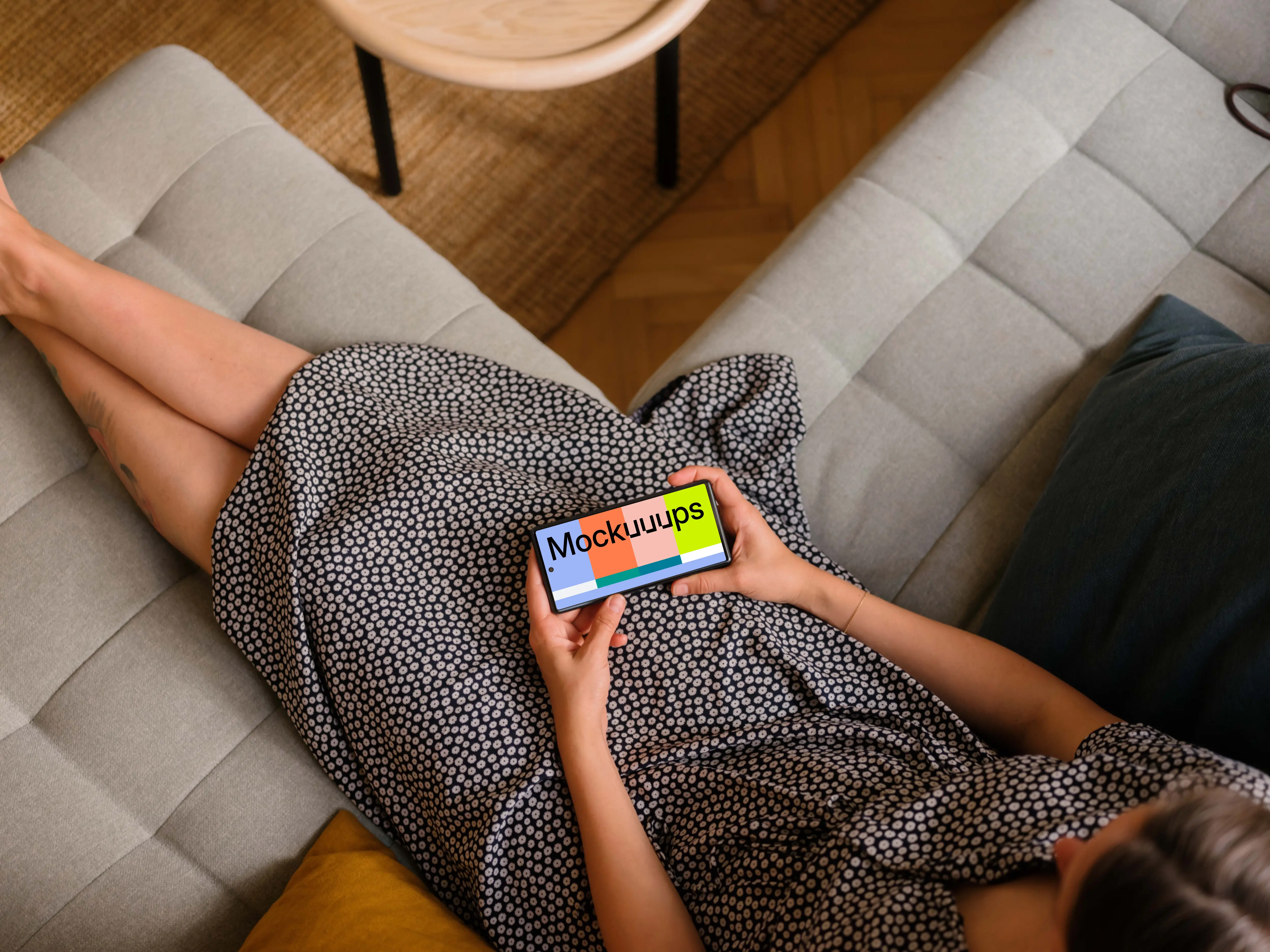Woman laying on sofa holding a Google Pixel 6 mockup