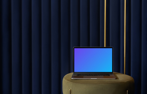 MacBook mockup on a stool with a blue curtain in the background