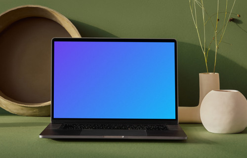 MacBook mockup on a table with flower vase in a green background