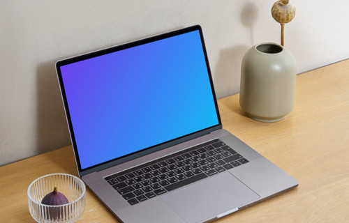 MacBook mockup on a wooden workstation table