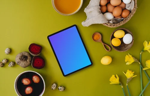 Easter eggs being colored next to a tablet mockup