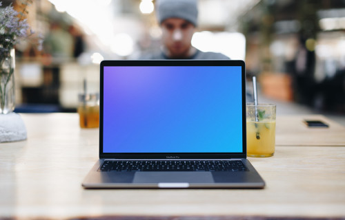 Front view of Macbook Pro mockup with co-worker behind