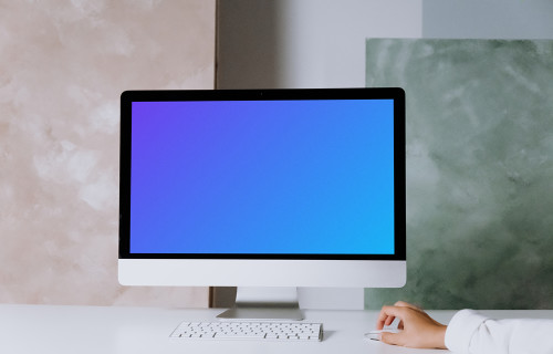 iMac mockup on a table with green and pink background