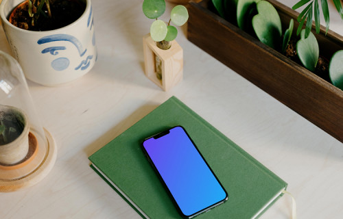 iPhone 13 Pro on a green notepad