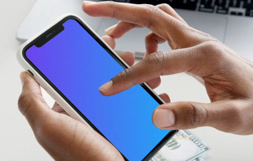 iPhone mockup in user’s hand with a MacBook