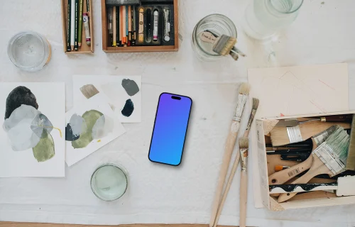 iPhone mockup surrounded by artistic tools