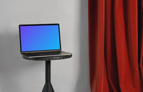 MacBook mockup on a black stool with red curtain in the background