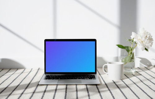 MacBook mockup on a patterned carpet with a cup at the side