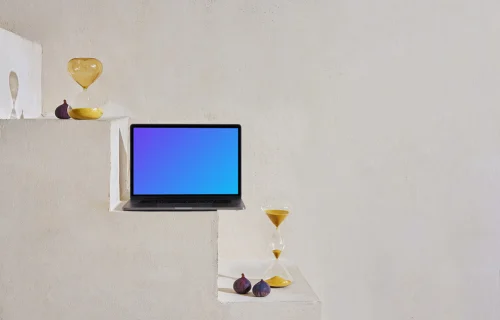 MacBook mockup on a staircase with hourglasses and onions at the side