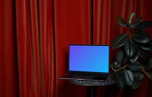 MacBook mockup on a stool beside flower pot