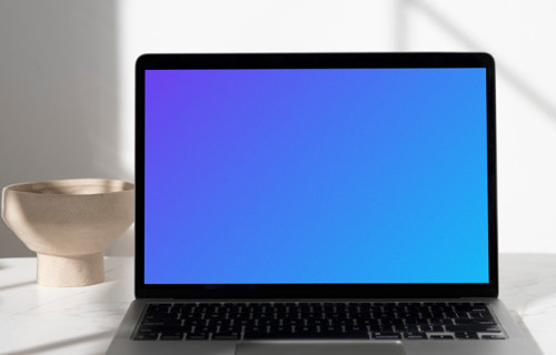 MacBook mockup sur une table avec un bol en céramique en arrière-plan