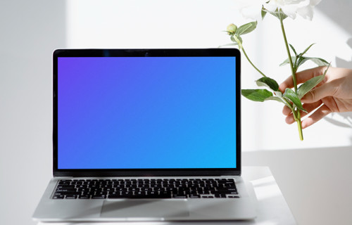 MacBook mockup on a white table close to the window