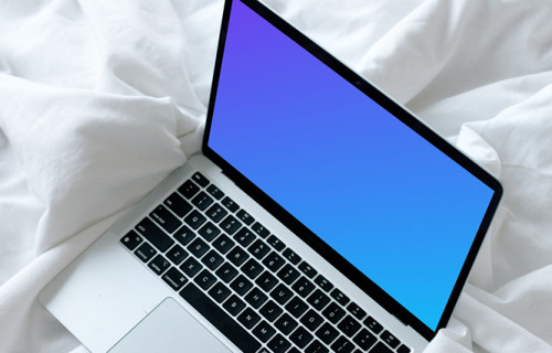 MacBook mockup resting on a white bed