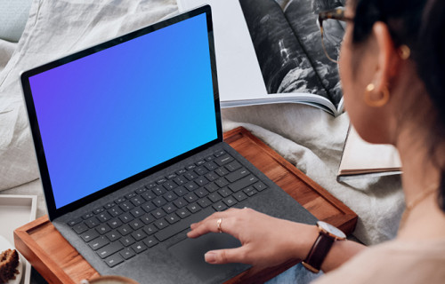 Microsoft Surface Laptop mockup used by a lady on a wooden slab