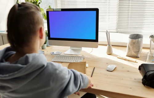 Mockup of a young girl using an iMac close to a window