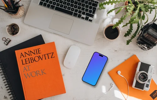 Mockup do dispositivo smartphone com livros e MacBook Pro