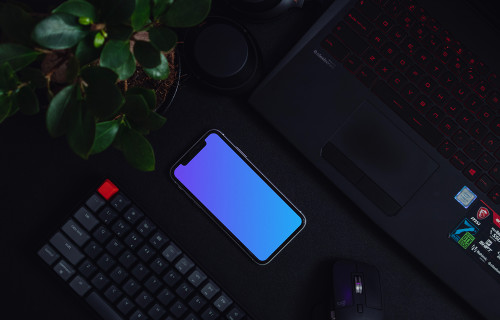 Night iPhone mockup on a table alongside a keyboard and flower pot