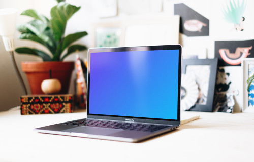 Side view of Macbook Pro mockup in a creative workspace