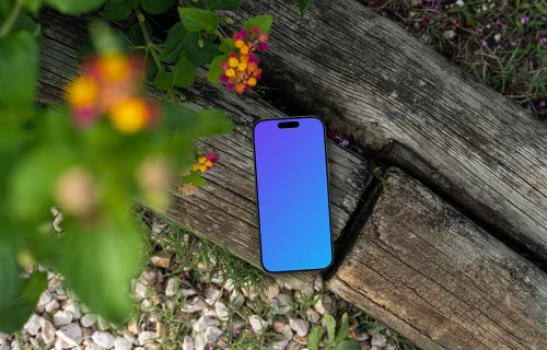 Smartphone mockup laying on wood in a garden