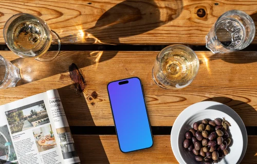 Smartphone mockup à côté des olives et du vin