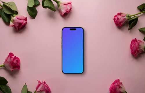 Smartphone mockup on a pink background among roses