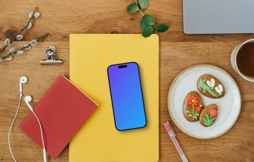 Smartphone mockup sur un cahier jaune dans un décor de Pâques