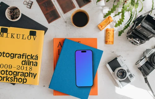 Smartphone mockup colocado sobre libros de colores