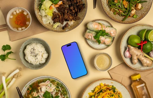 Smartphone mockup entouré de repas de cuisine vietnamienne