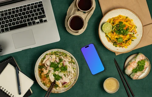 Smartphone mockup rodeado de comida vietnamita