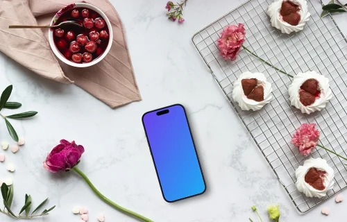 Smartphone mockup con flores rosas y postres