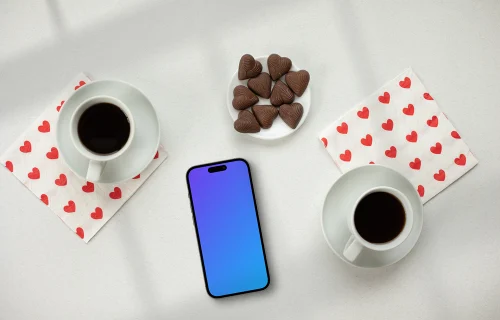 Smartphone mockup with two coffees and heart-shaped chocolates