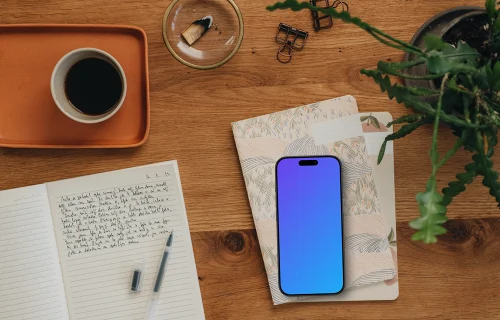 Styled journaling scene with an iPhone mockup