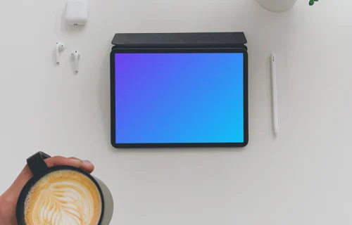 Tablet mockup on a white table with Airpods at the side