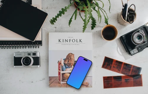 Vue de dessus du téléphone mockup entouré de caméras analogiques et de négatifs