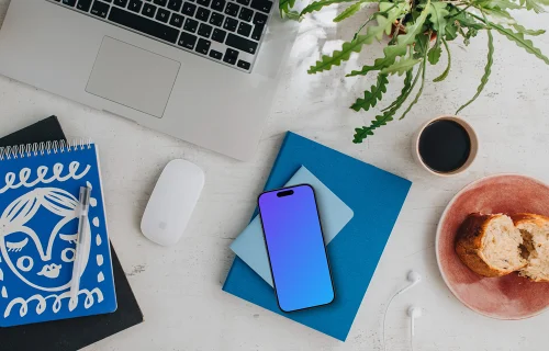 Top view of smartphone mockup next to MacBook and Magic Mouse