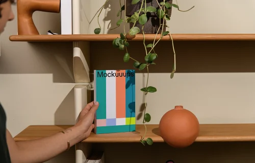 B-format book mockup on a wooden shelf with decor