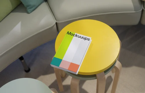 C-format book mockup on colorful round tables in a cozy living area