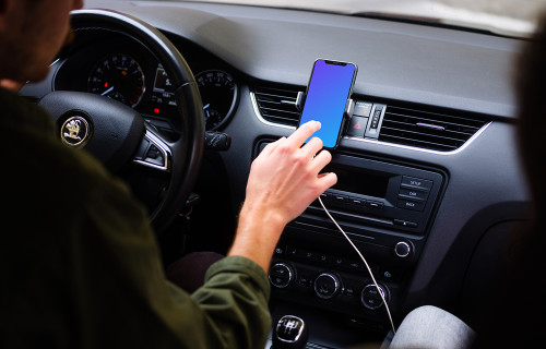 Car driver tapping iPhone 11 mockup in parked car