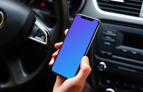 Drivers hand holding iPhone 11 mockup from behind the wheel