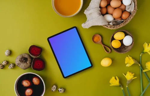 Easter eggs being colored next to a tablet mockup