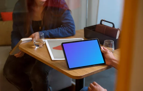 Hand holding an iPad Air mockup in office