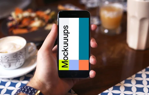 Holding iPhone 6 mockup at coffee